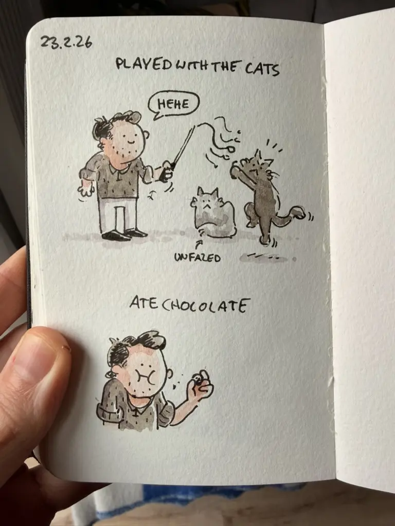 Marcel plays with two cats using a teaser toy, then eats chocolate.